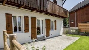 A traditional chalet with wooden shutters, a balcony, and a paved courtyard. - New apartment in the center of the village and 150 meters from the ski bus. (Samoëns)