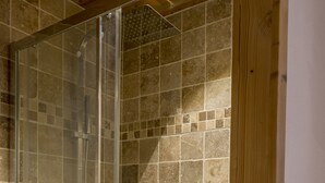 A glass-enclosed shower with a tiled wall and wooden framing. - New apartment in the center of the village and 150 meters from the ski bus. (Samoëns)
