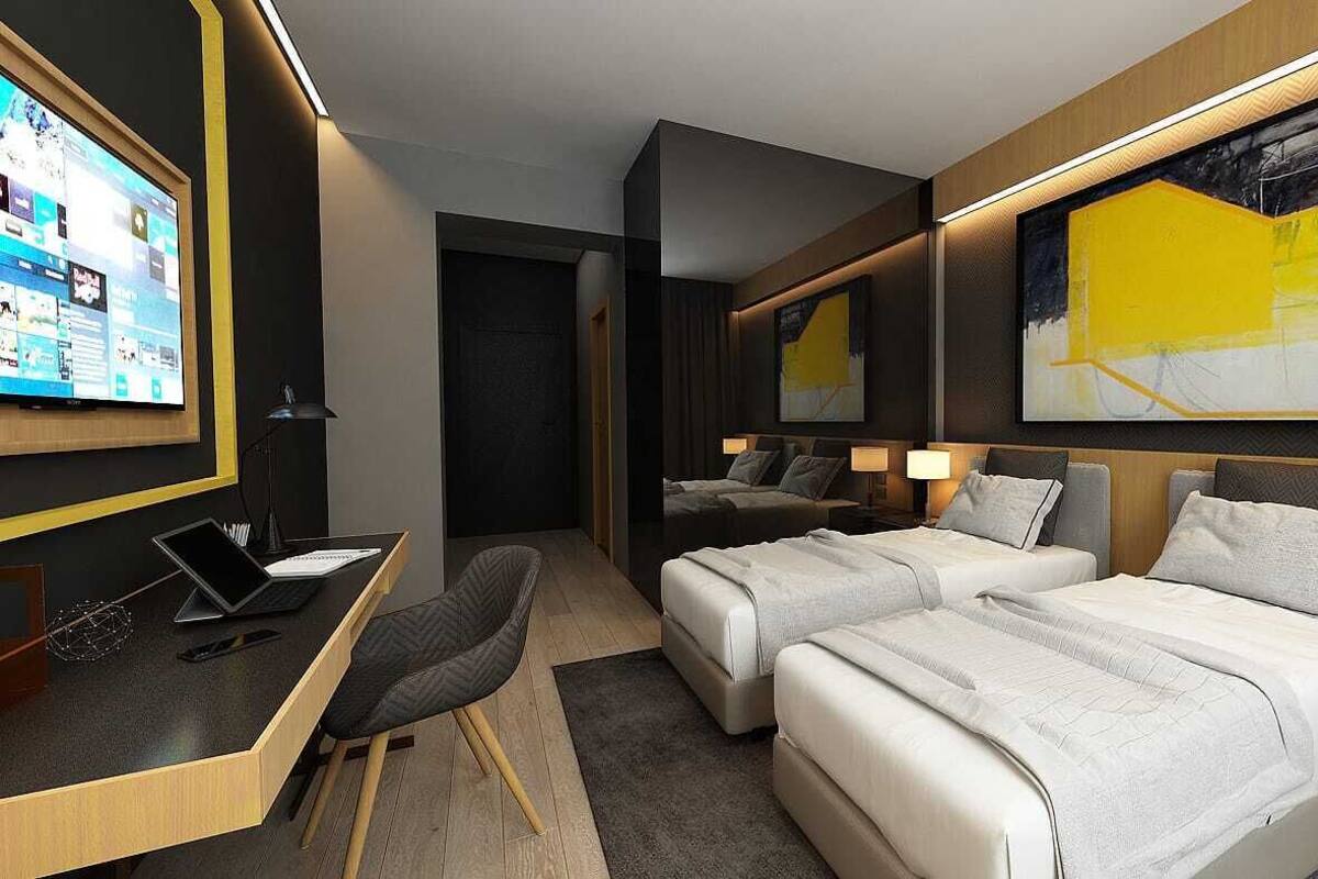 Ein modernes Hotelzimmer mit Schreibtisch, zwei Betten, einem großen Kunstwerk an der Wand und einem Fernseher, der eine Webseite anzeigt.