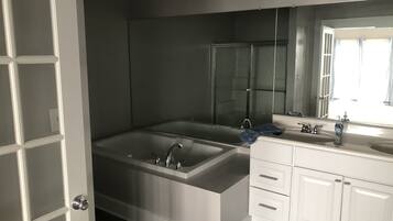 Een bad/douchecombinatie, handdoeken, zeep, shampoo