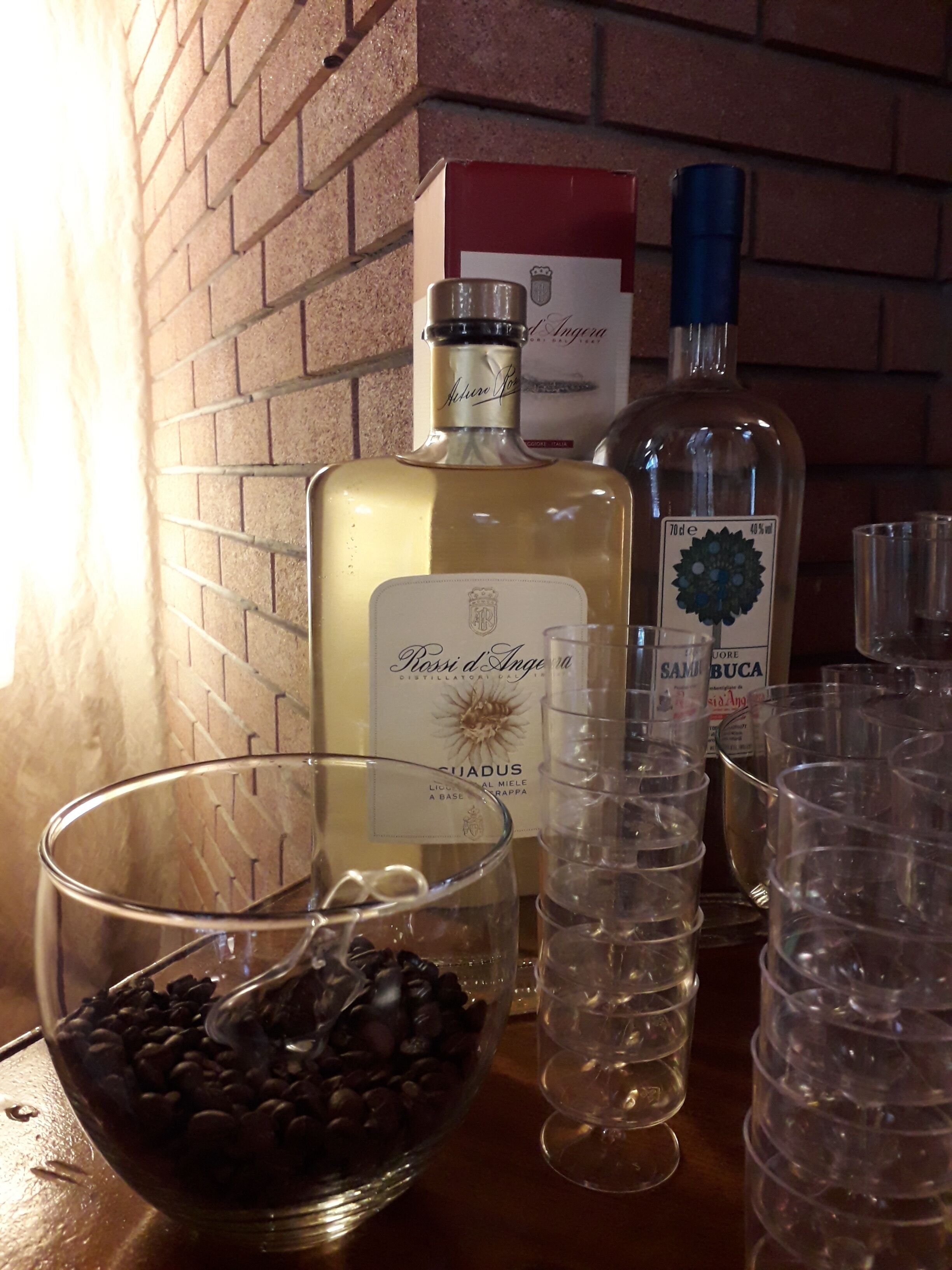 Ein Tisch mit alkoholischen Getränken, Gläsern und einer Schüssel Schokoladenstückchen.