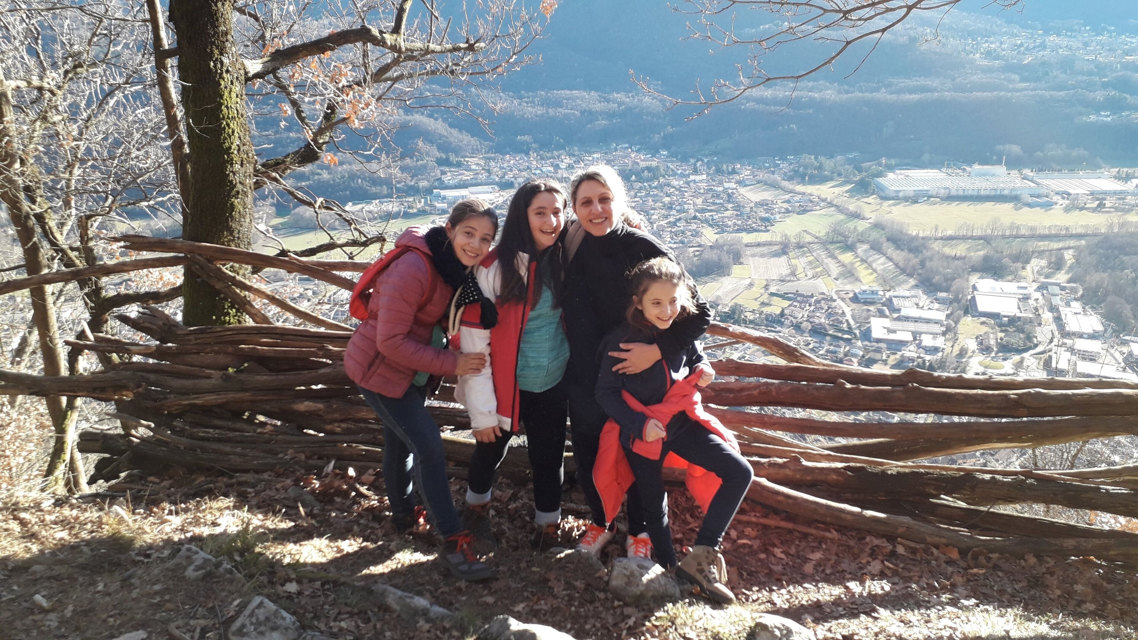 A family on a mountain ridge with a view of a town below.