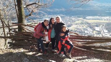 A family on a mountain ridge with a view of a town below.