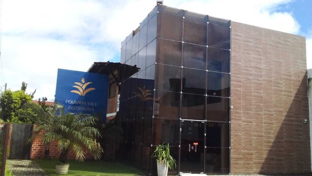 A modern building with a glass facade and a sign reading "Pousada Vale do Gravata". - Pousada Vale do Gravatá (Gravata)