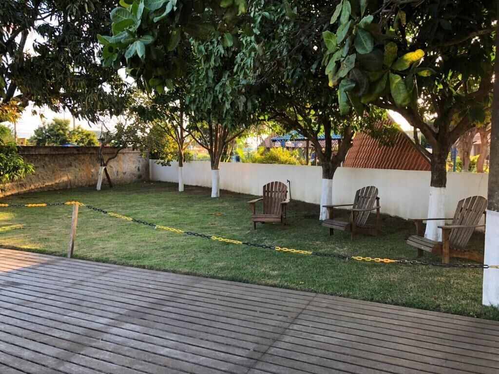 Um deck de madeira com área gramada e paredes brancas.