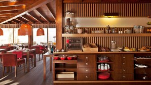 A restaurant with wooden interiors, a coffee station, and a buffet area. - Bright Apartment | Kitchenette + Air-Conditioning (Albufeira)