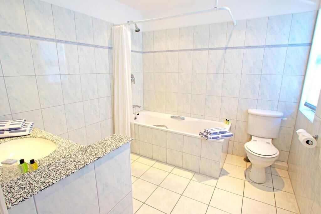 Une salle de bain avec une baignoire, des toilettes et un lavabo.
