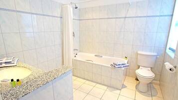 Une salle de bain avec une baignoire, des toilettes et un lavabo.