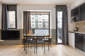Una cocina moderna con comedor, ventanas amplias y un televisor de pantalla plana.