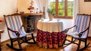 Une pièce chaleureuse avec deux fauteuils à bascule, une table ronde et une cheminée.