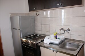 Departamento familiar (3) | Cocina privada | Refrigerador, horno, parrilla de estufa y tetera eléctrica 