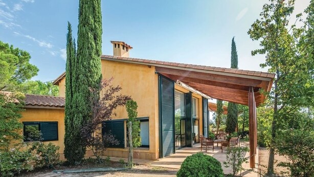 A modern house with a yellow facade, large windows, and a covered patio area. - Oliver Conti (House, Capmany) (Capmany)