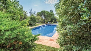 A rectangular swimming pool with a tiled deck, surrounded by dense green foliage and trees. - Oliver Conti (House, Capmany) (Capmany)