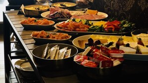 A buffet with various dishes, including fruits, vegetables, and meats. - Veiholmen Brygge (Smøla)