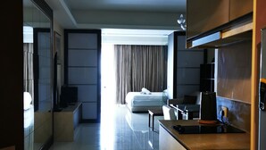 A modern hotel room with a kitchenette, a bed with a view, and a bathroom with a large mirror. - Classic Studio in Kuala Lumpur 10 minutes to city center (Kuala Lumpur)