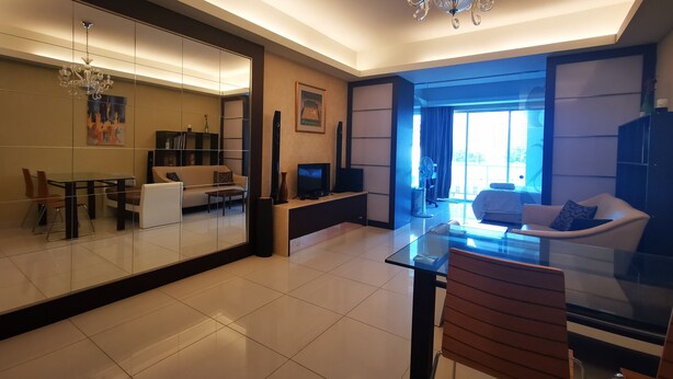 A modern living room with a glass dining table, a sofa, a TV, and a chandelier. - Classic Studio in Kuala Lumpur 10 minutes to city center (Kuala Lumpur)