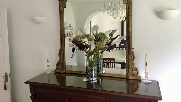 A wooden dresser with a glass top, a mirror with an ornate frame, and a vase with flowers. - Self Contained Stay, set within 7 acres of gated grounds, for 2 or 3 guests (Kingsfold)