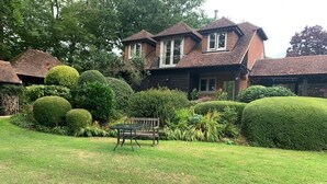 A house with a well-maintained garden, a bench, and a lawn. - Self Contained Stay, set within 7 acres of gated grounds, for 2 or 3 guests (Kingsfold)