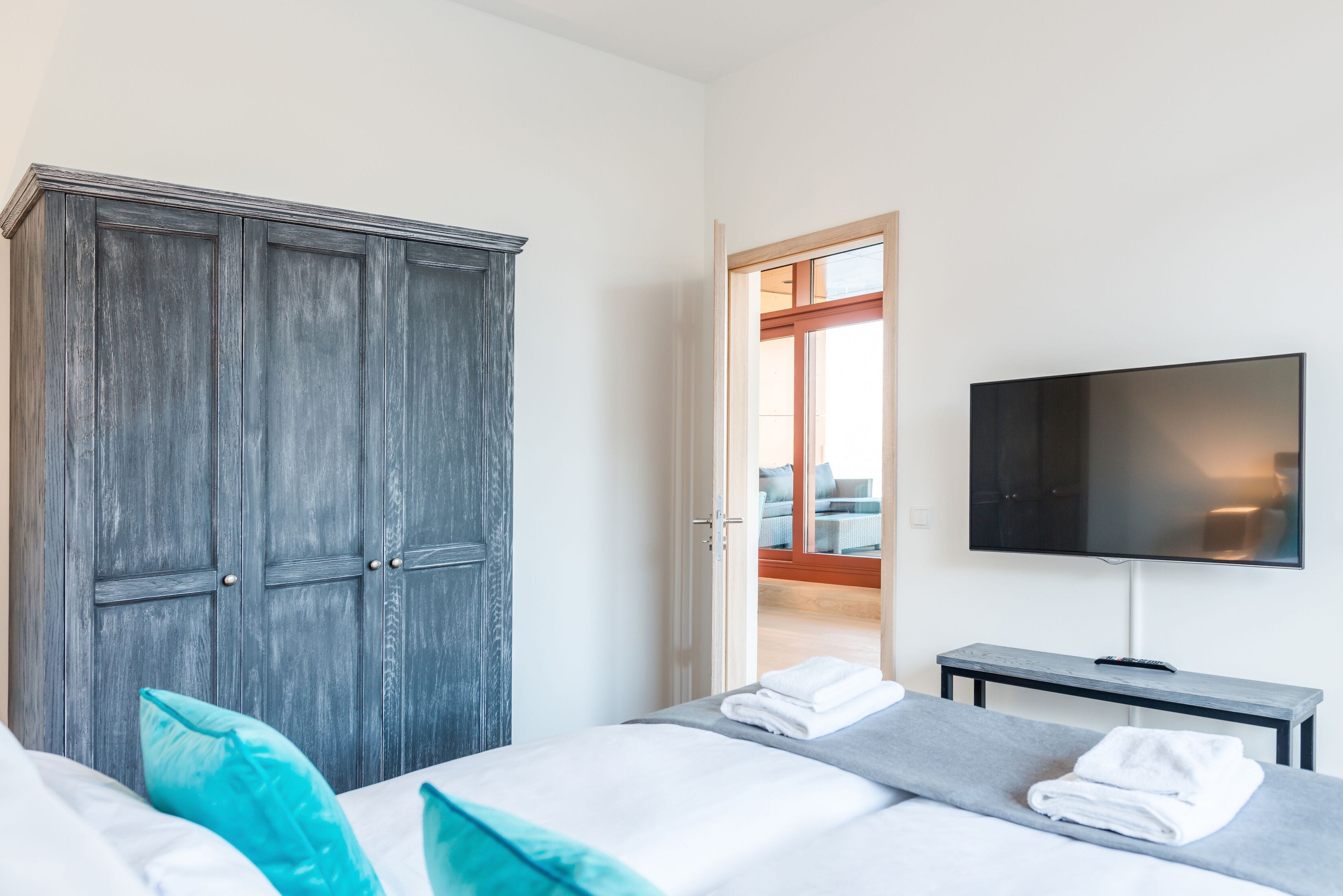 Una habitación de hotel con cama, televisión, armario y vistas al exterior.