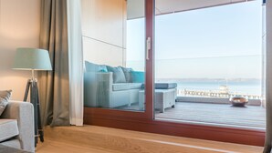 Ein modernes Zimmer mit einer Couch, einer Lampe und Blick auf einen Steg.