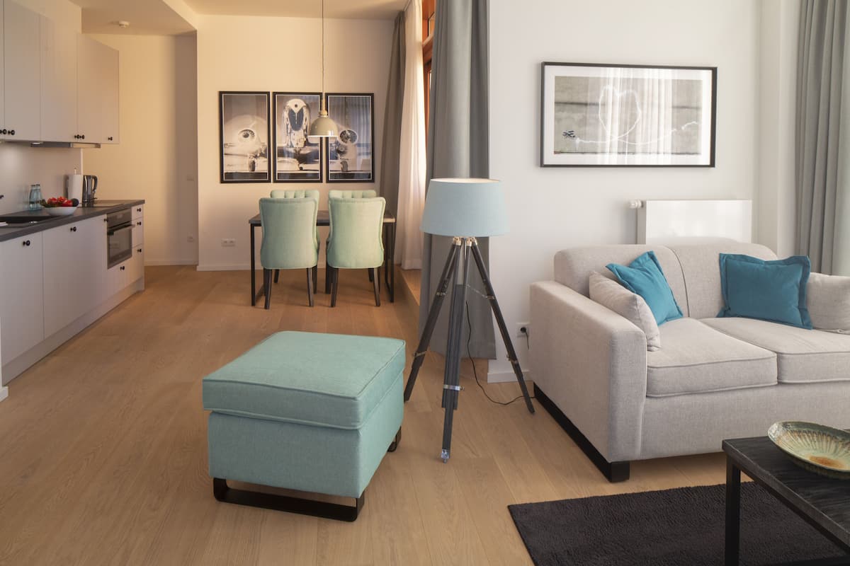 Ein modernes Wohnzimmer mit Sofa, Hocker und Essbereich.