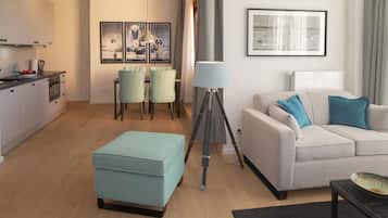 Een moderne woonkamer met een bank, voetenbankje en eethoek.
