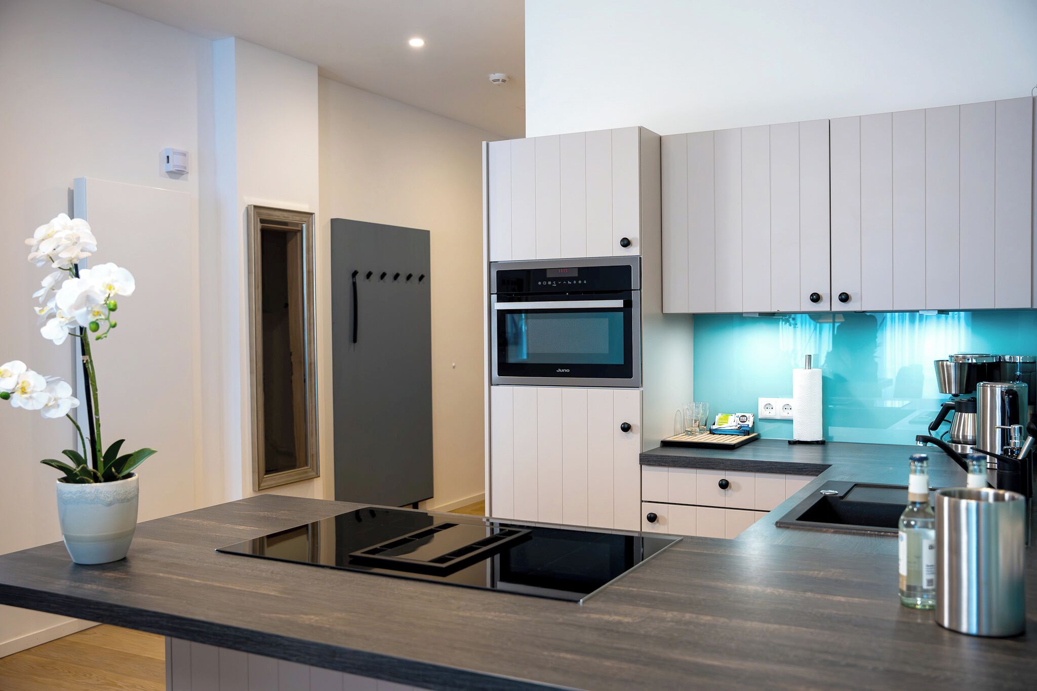 Una cocina moderna con horno integrado, microondas y cafetera.