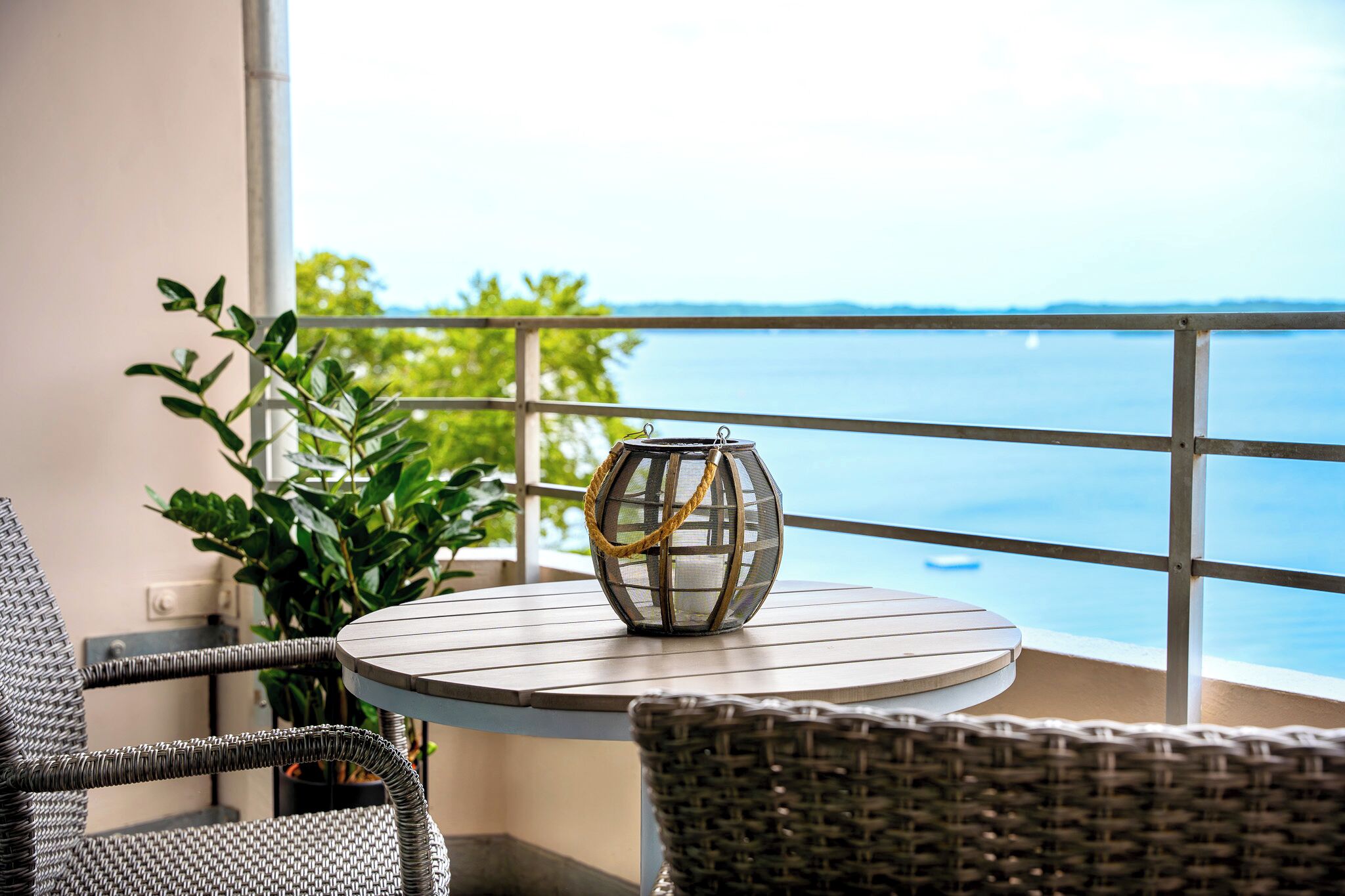 A balcony with wicker chairs, a round table, and a decorative globe.