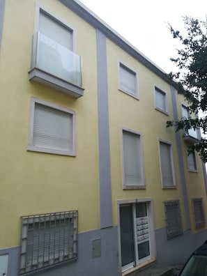 A multi-story building with a yellow facade, multiple windows with shutters, and a gated entrance. - Lisbon Grand View (Lisbon)