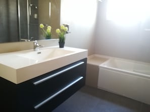 A bathroom with a double sink vanity, a mirror, a potted plant, and a bathtub. - Lisbon Grand View (Lisbon)