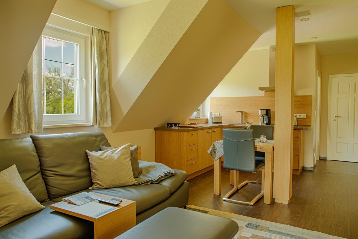 A cozy loft-style living space with a sofa, a dining table, and a kitchen area.