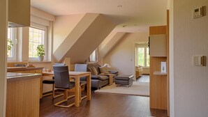 A spacious loft with a dining area, a sofa, and a small kitchenette.