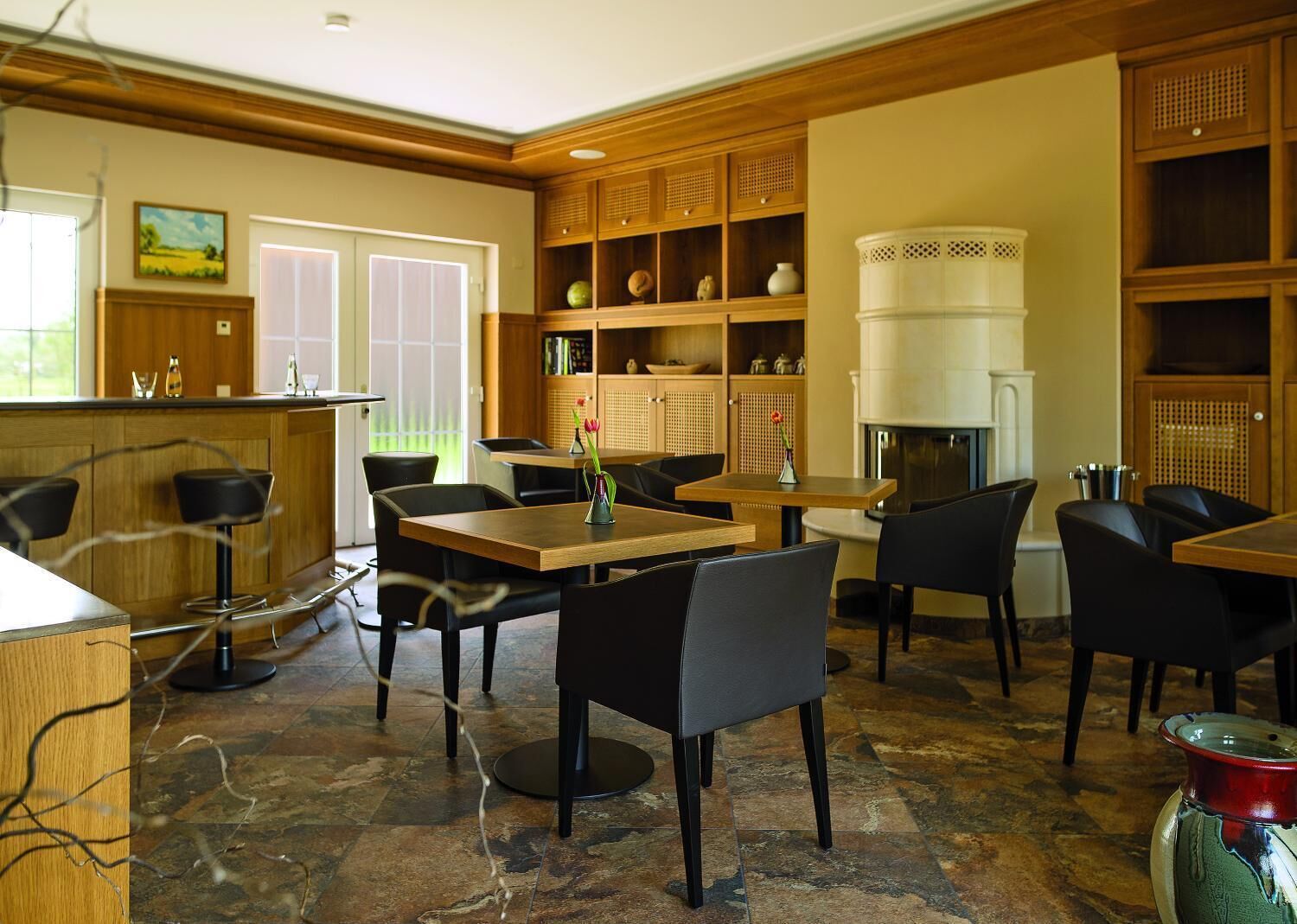 A dining area with wooden tables and chairs, a bar area, and a fireplace.