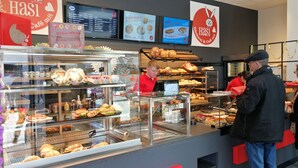 Un bancone di panetteria con diversi prodotti da forno esposti, tra cui pane e dolci.