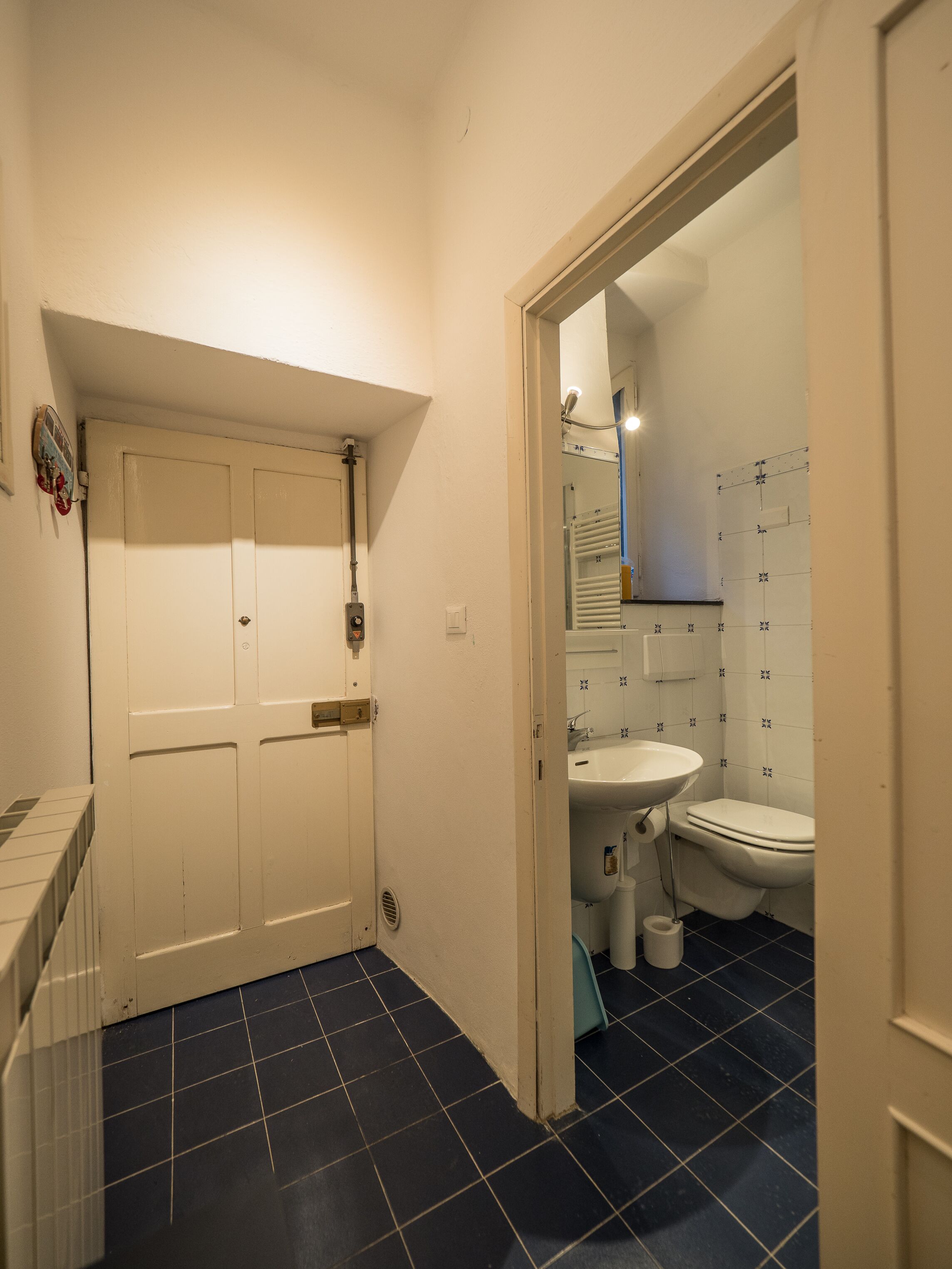 A bathroom with a white door, a sink, and a toilet.