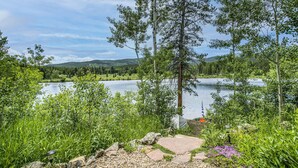 Une vue sur le lac, avec un sentier en pierre, des arbres et un ciel dégagé.