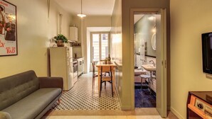 A compact living space with a kitchenette, a dining area, and a sofa. - Trastevere Vintage (Rome)