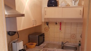 Cocina compacta con estufa, microondas, tostadora y lavaplatos.