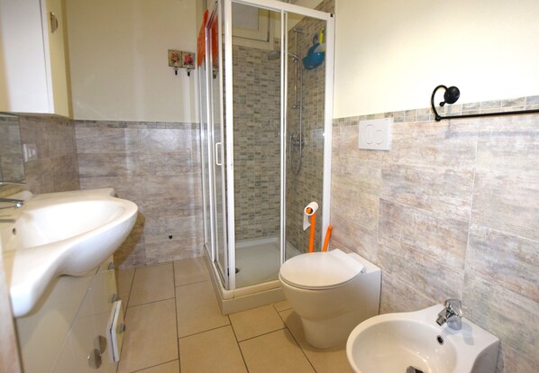 Regadera, bidet, toallas, papel de baño 