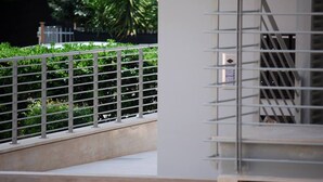 A metal railing with a view of greenery and a building in the background. - B&B Angelo (Ascoli Piceno)