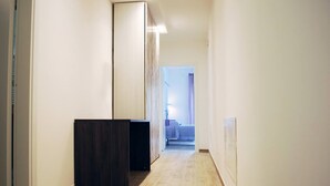 A narrow hallway with a wooden floor and a dark-colored counter on the left. - B&B Angelo (Ascoli Piceno)