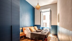 A modern bedroom with a bed, bedside table, and a hanging light fixture. - Trastevere Vintage 2 (Rome)