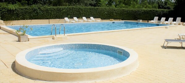 En säsongsöppen utomhuspool och solstolar