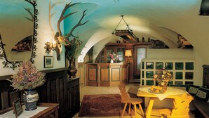Une salle à manger spacieuse avec un plafond haut, un lustre et une table en bois rustique.
