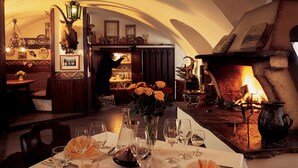 Un coin repas avec une table mise pour le repas, une cheminée et diverses décorations.