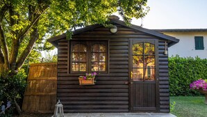 A wooden cabin with a front door, windows, and a small porch area. - B&B La Serra (San Miniato)