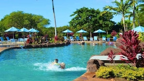A swimming pool with lounge chairs and umbrellas, surrounded by tropical vegetation. - Poipu Beach House: Ocean View, Lush Garden, Beach! (Koloa)