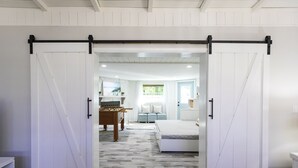 A room with a large sliding door leading to a bedroom with a bed and a sofa. - Golf cart Inc + 4bd/2bth + private pool! (Holmes Beach)