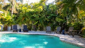 A swimming pool with lounge chairs and a white fence. - Golf cart Inc + 4bd/2bth + private pool! (Holmes Beach)