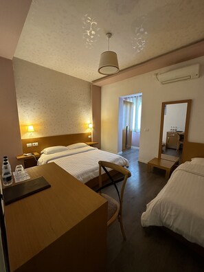 A hotel room with two beds, a desk, a chair, a mirror, and a ceiling light fixture. - ALBON Park (Berat)